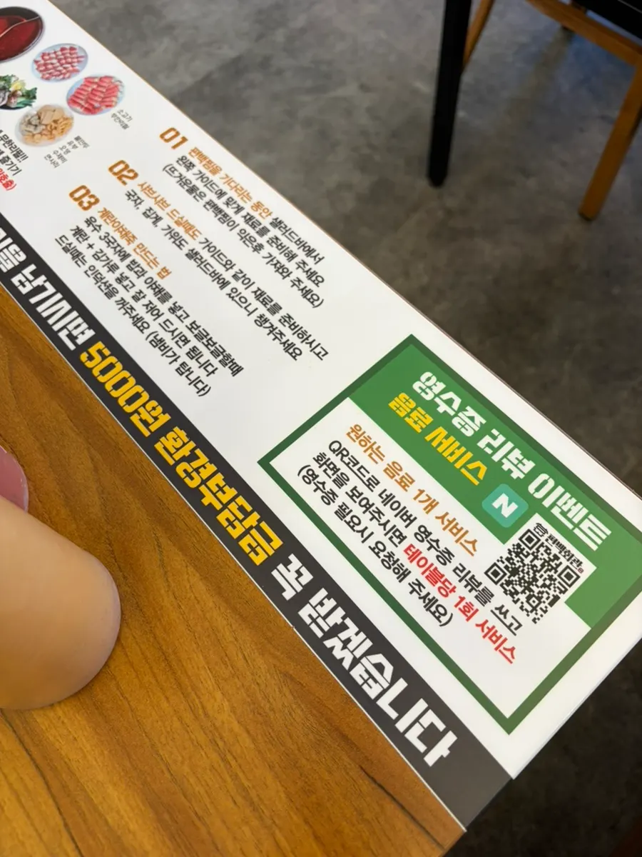 Cartel de instrucciones sobre el pyeonbaekjjim y el shabu-shabu en la mesa