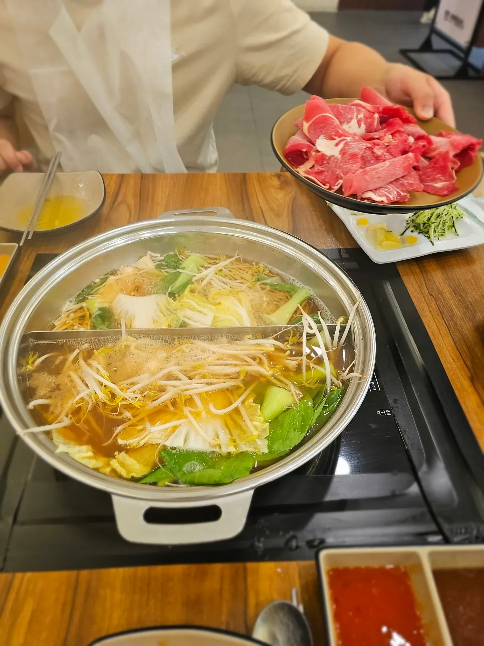 Meat picked up together with enoki mushrooms in shabu-shabu