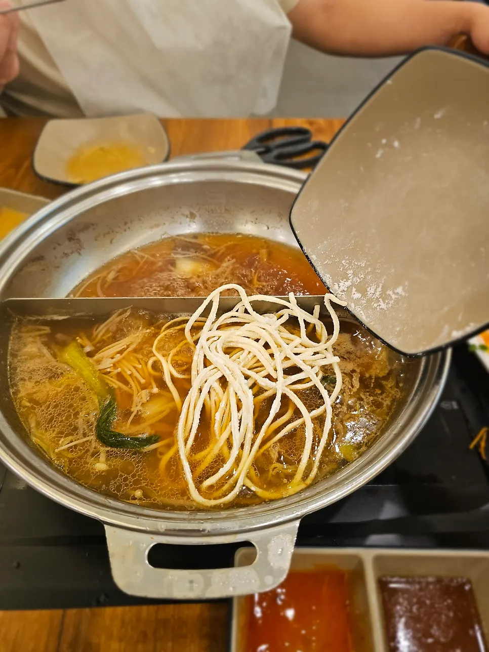 Knife-cut noodles simmering in the pot