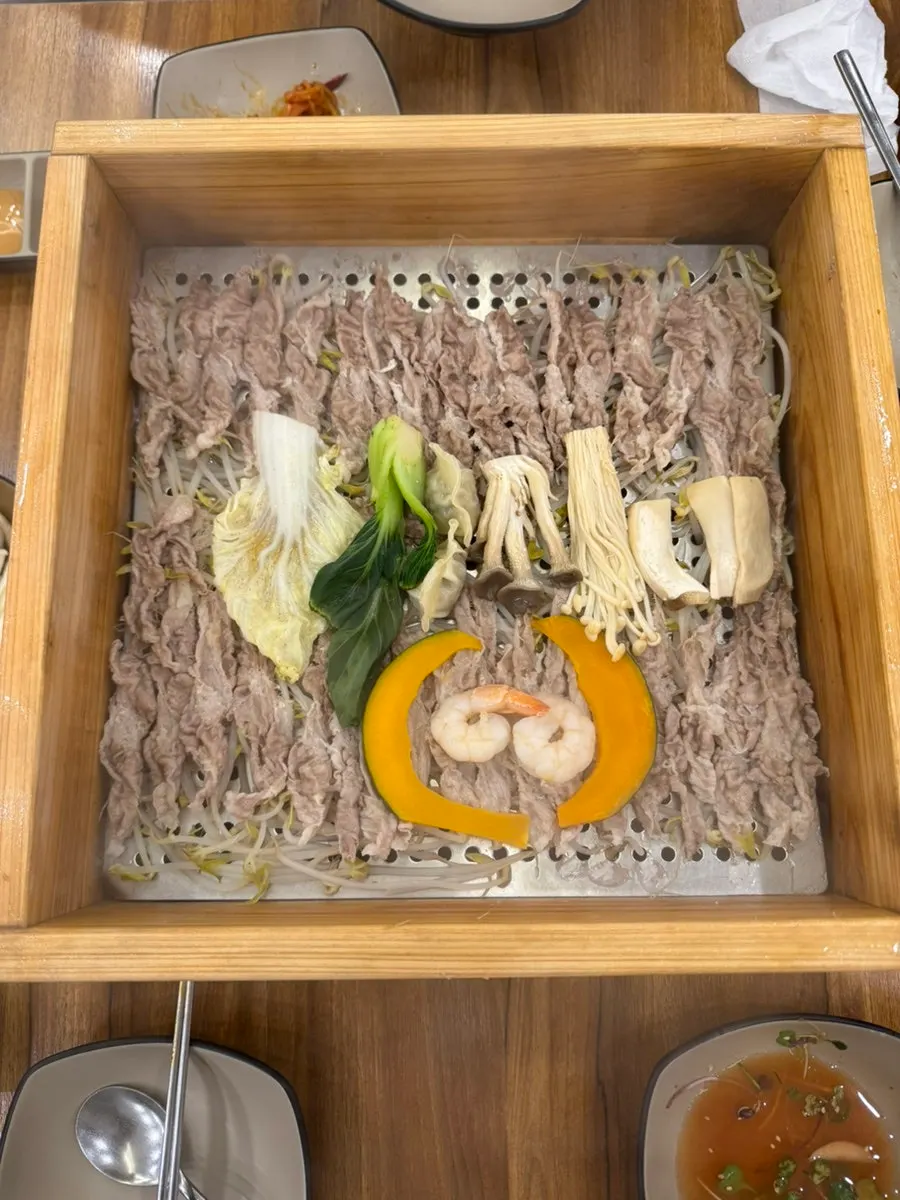 뚜껑을 연 편백찜 고기와 숙주