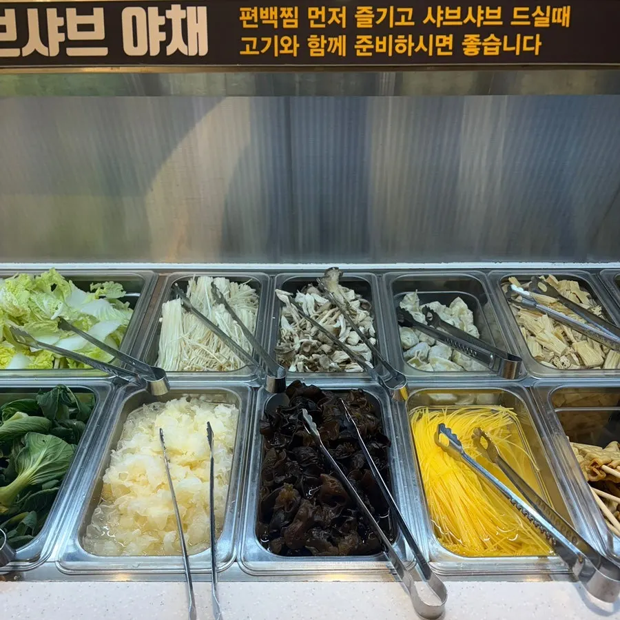 A variety of side dishes and vegetables laid out at the salad bar