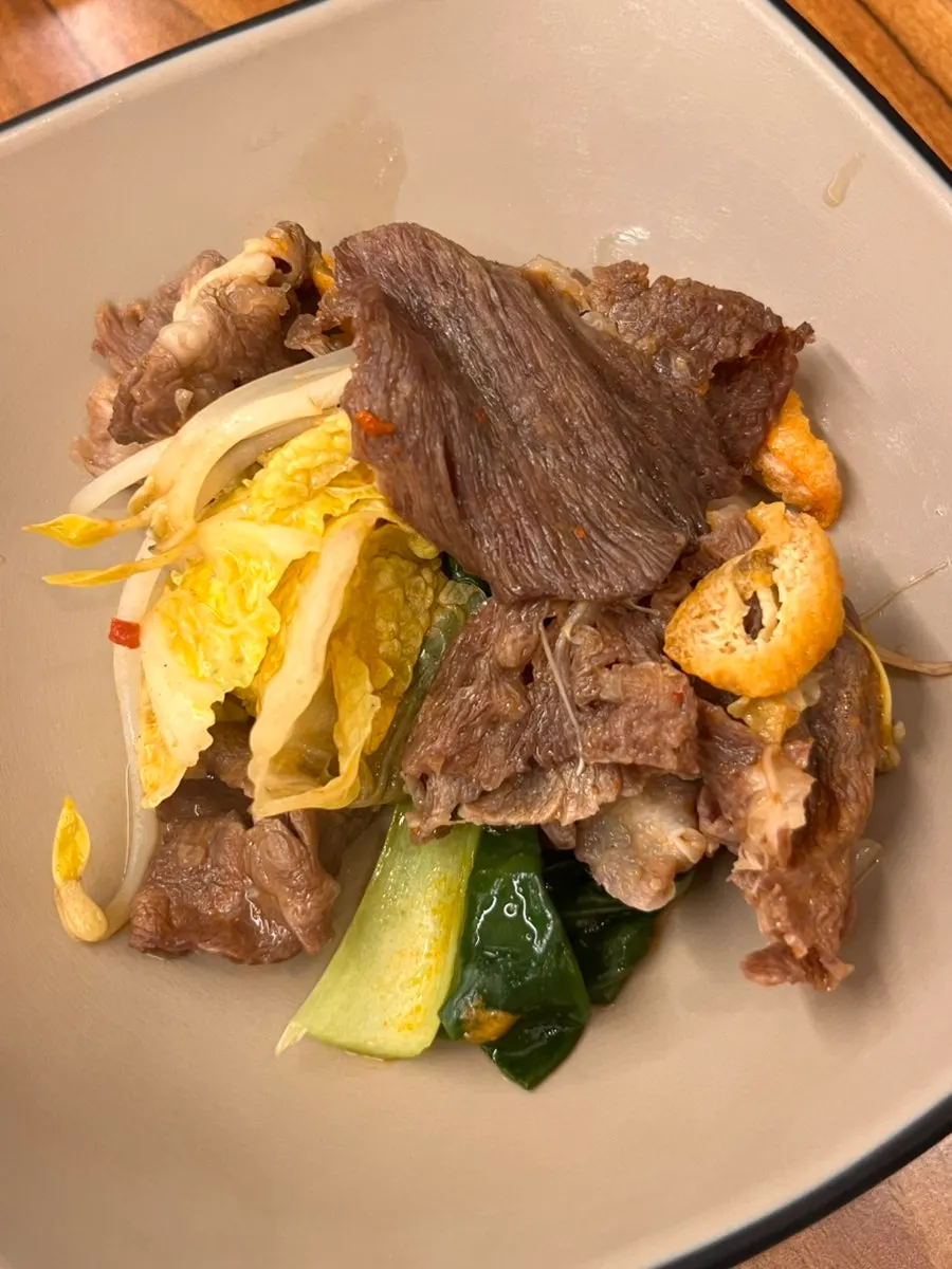 Cooked shabu-shabu meat lifted out of the broth