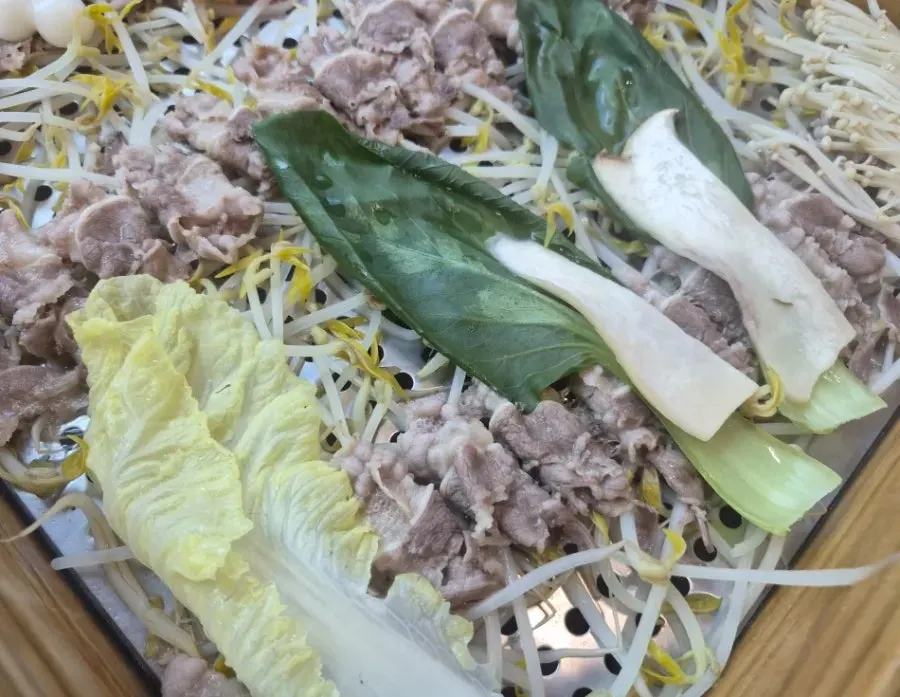 A piece of cypress-steamed pork dipped in sauce