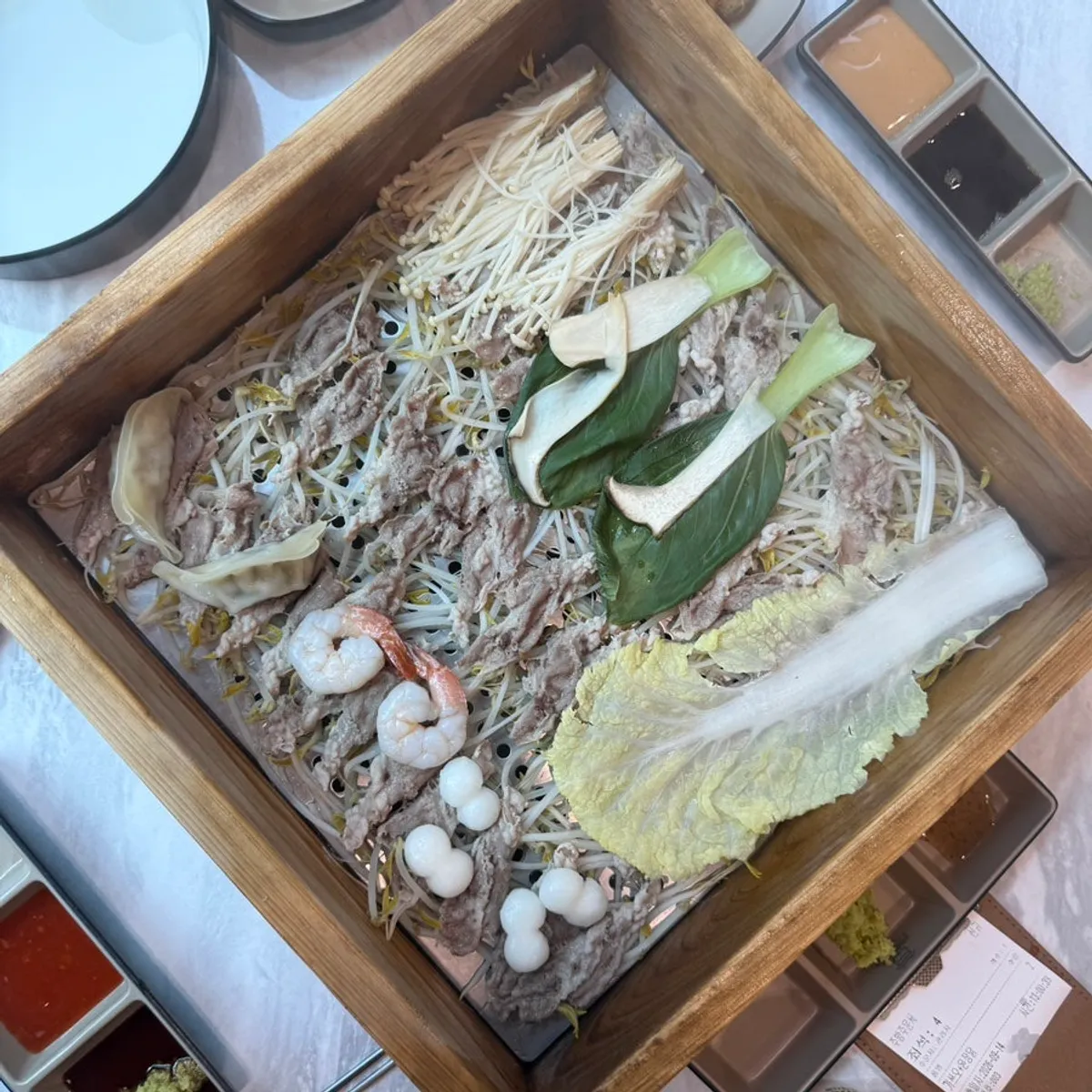 Square photo of a full cypress steamed dish spread at Pyeonbaek Hoegwan Siheung Janggok Branch