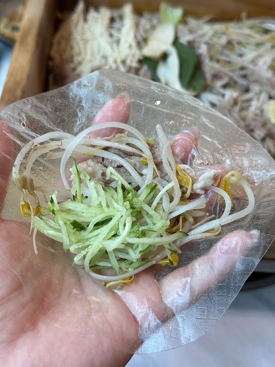 Lid removed, revealing vegetables and meat packed inside the cypress steamed dish