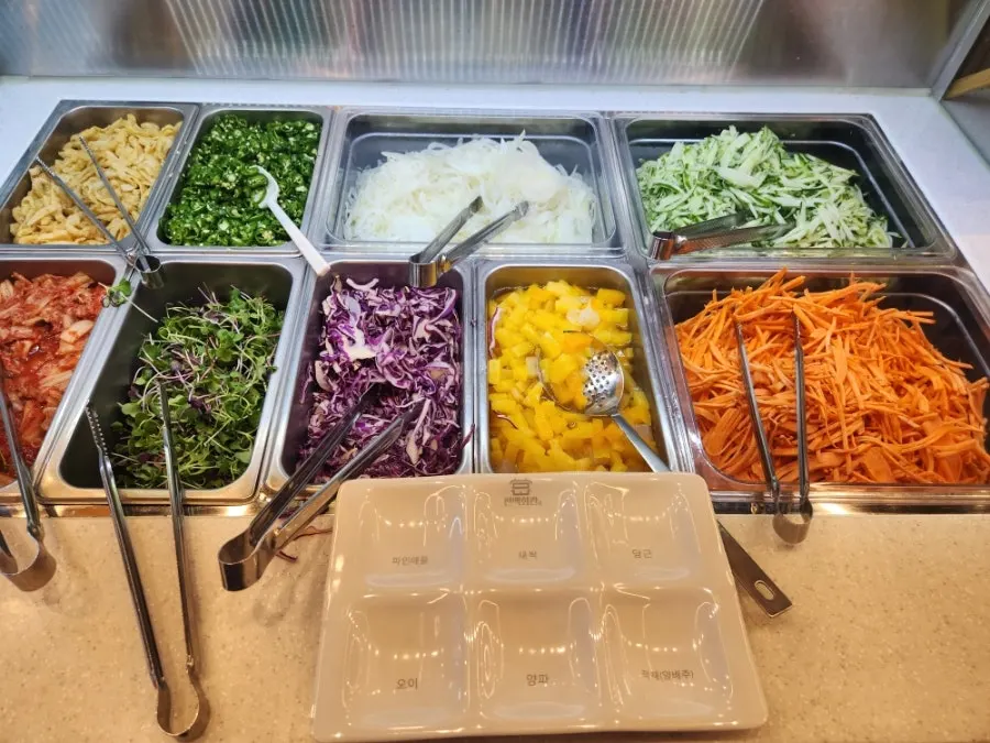 Self-serve bar with shabu-shabu vegetables and rice-paper roll vegetables