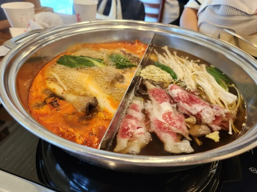 Meat and vegetables cooking in the boiling shabu-shabu broth