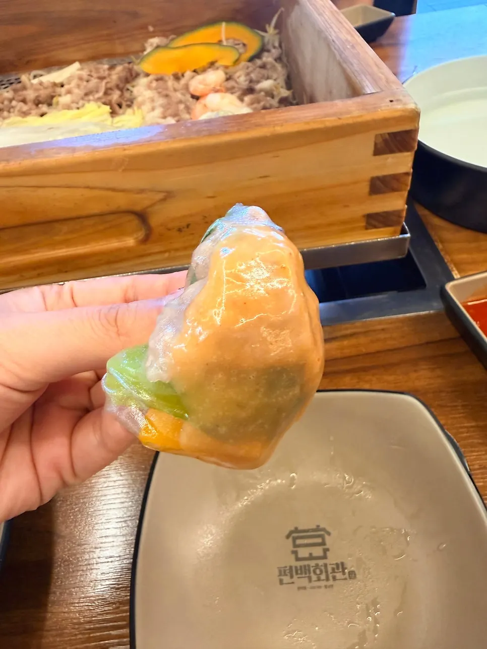A rice-paper roll dipped in sauce