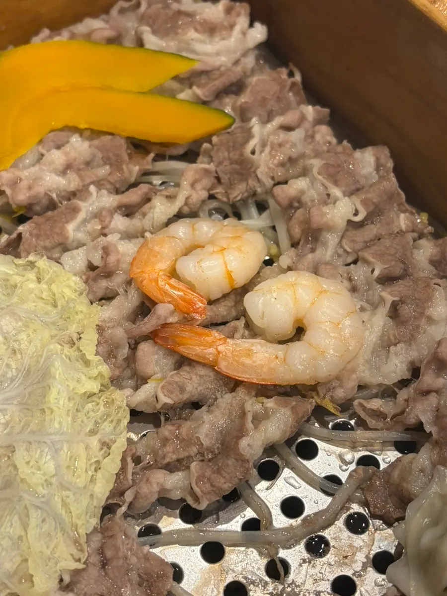 Inside the cypress steam pot with cooked woo-samgyeop, bean sprouts, and shrimp