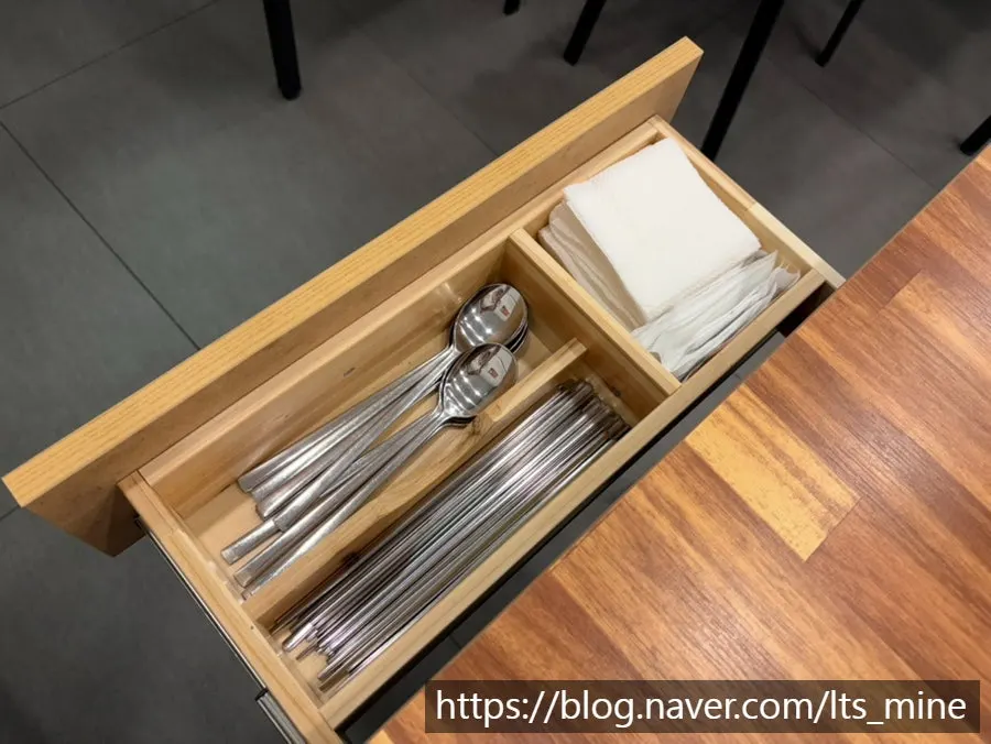 Drawer under the table with spoons and tissues