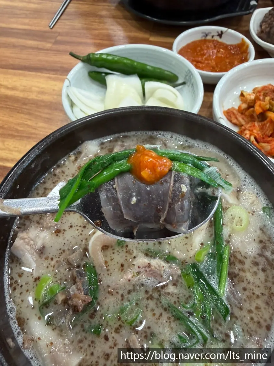 A spoonful of sundae-guk eaten with kimchi