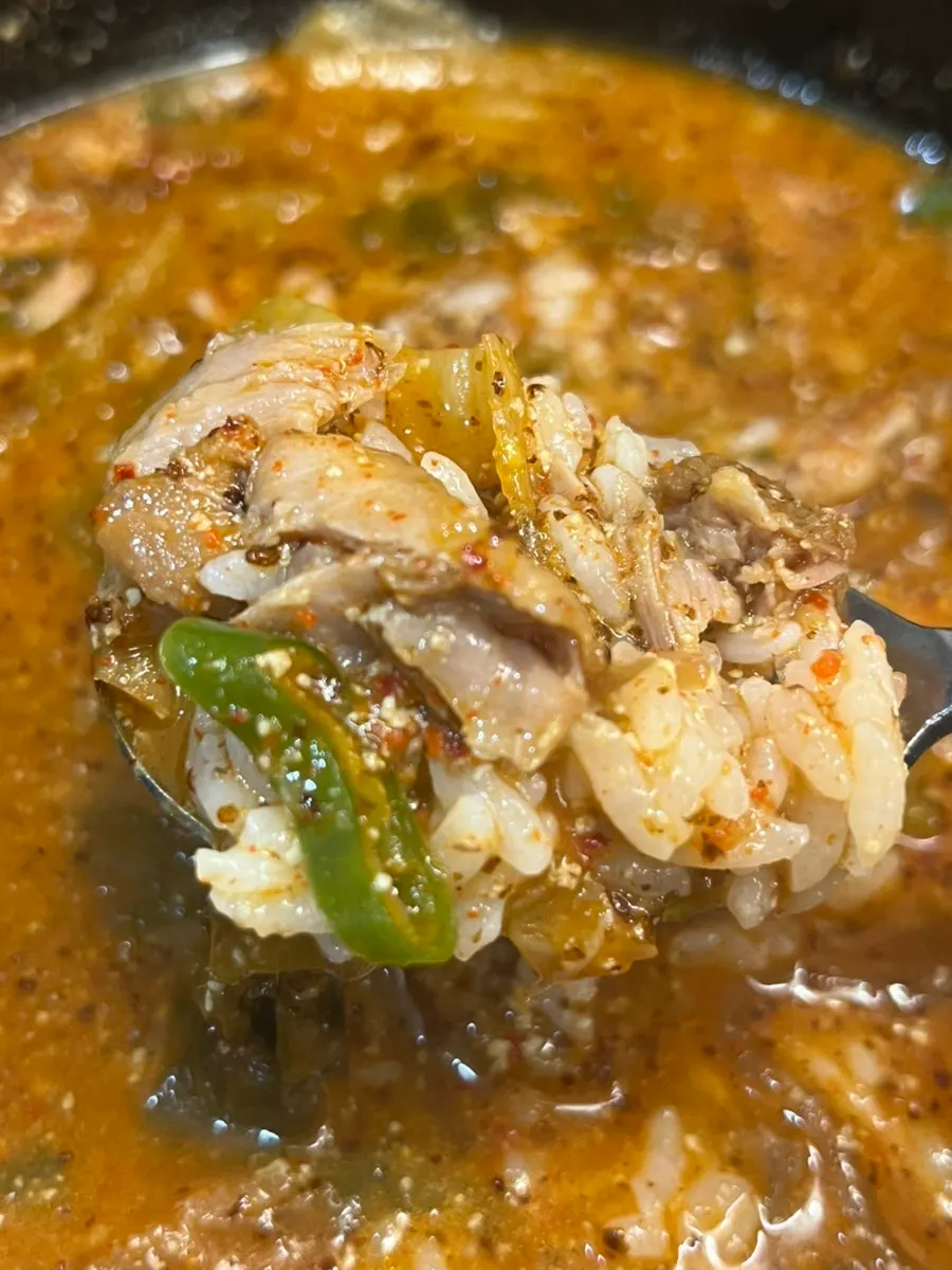 Meat pulled off the bone with a spoon in the haejangguk