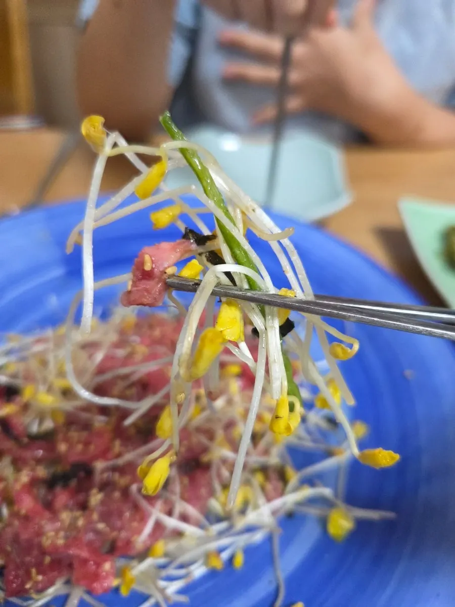 Close-up of a single bite of buckwheat sprout beef tartare