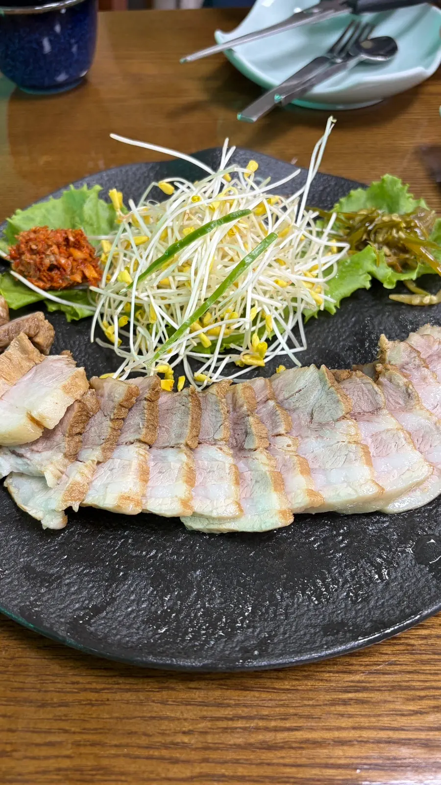 A piece of pork belly with buckwheat sprouts