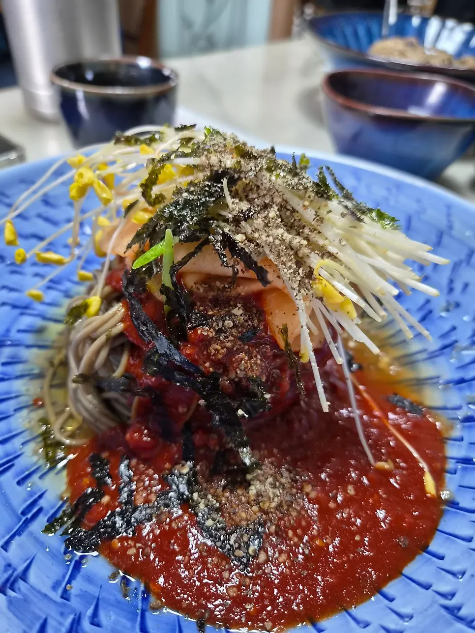 Water-style makguksu noodles mixed with soy sauce and perilla oil