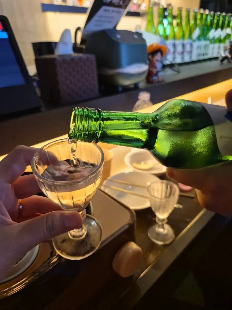A shot glass of Chamisul soju paired with sukiyaki and yurinchi