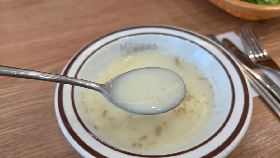 A bowl of soup with pepper sprinkled on top