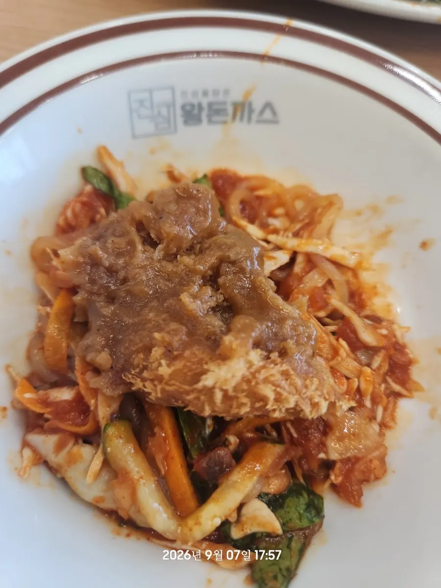 A piece of king donkatsu dipped in sauce