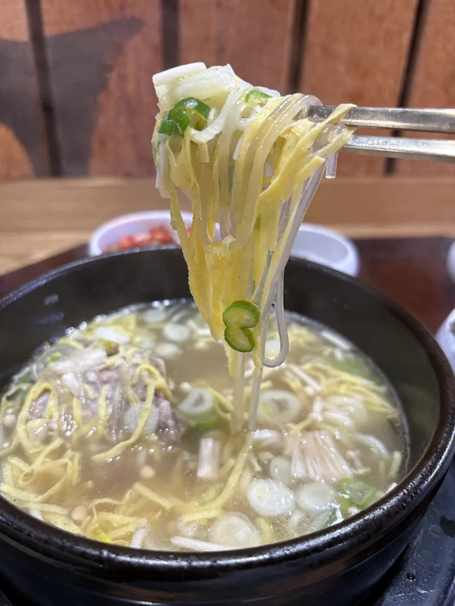 Table spread with bone kalguksu, bone soup rice, and suyuk