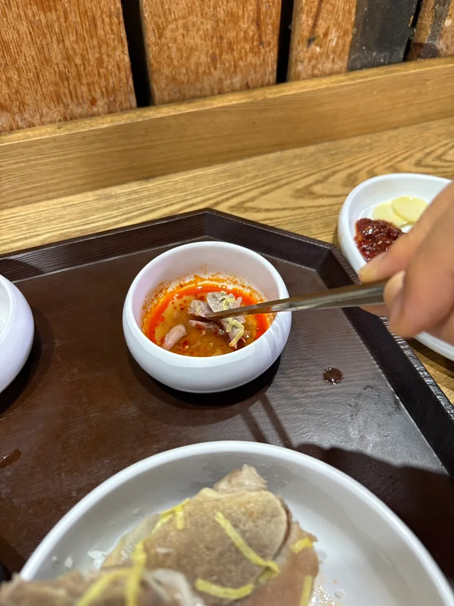 Bowl of bone kalguksu topped with chunky bone meat