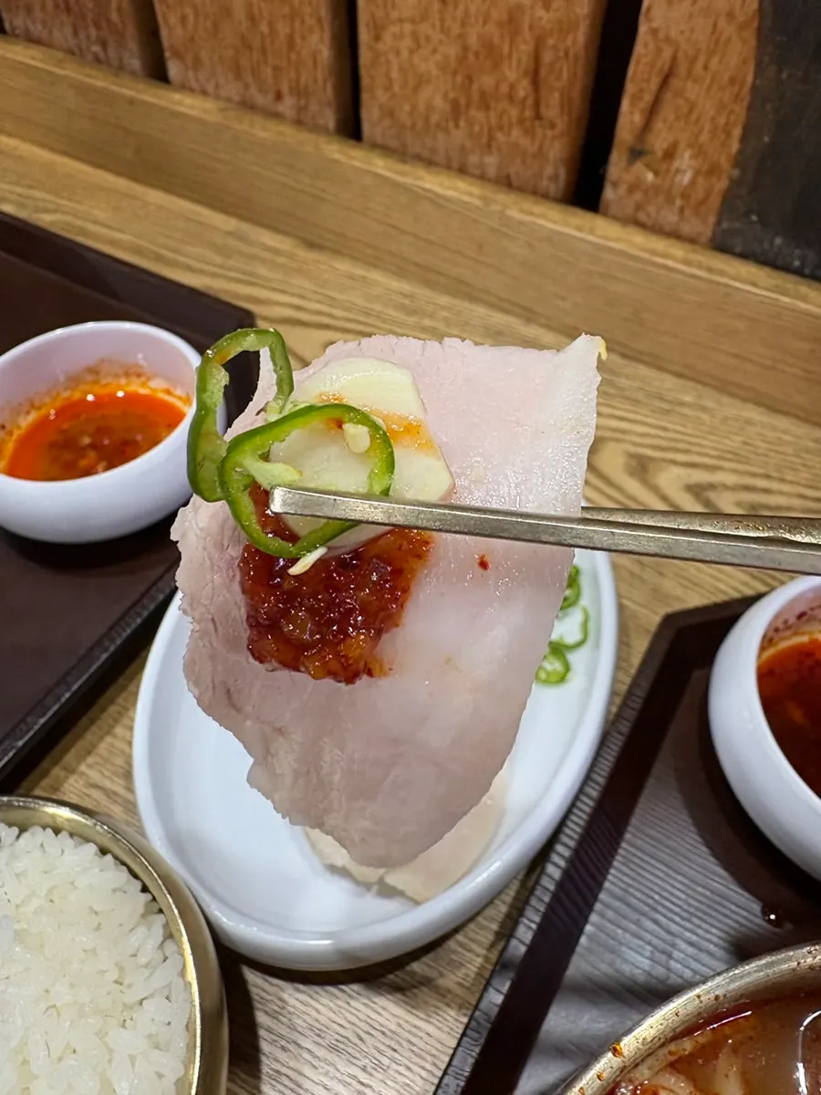 Suyuk eaten alongside bone kalguksu at the table