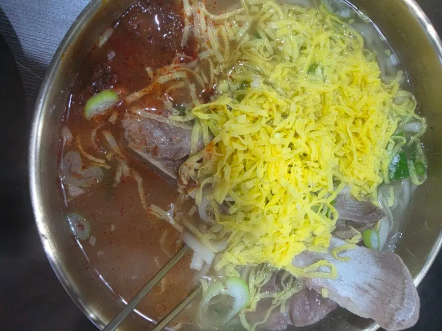 Fideos kalguksu servidos en caldo picante