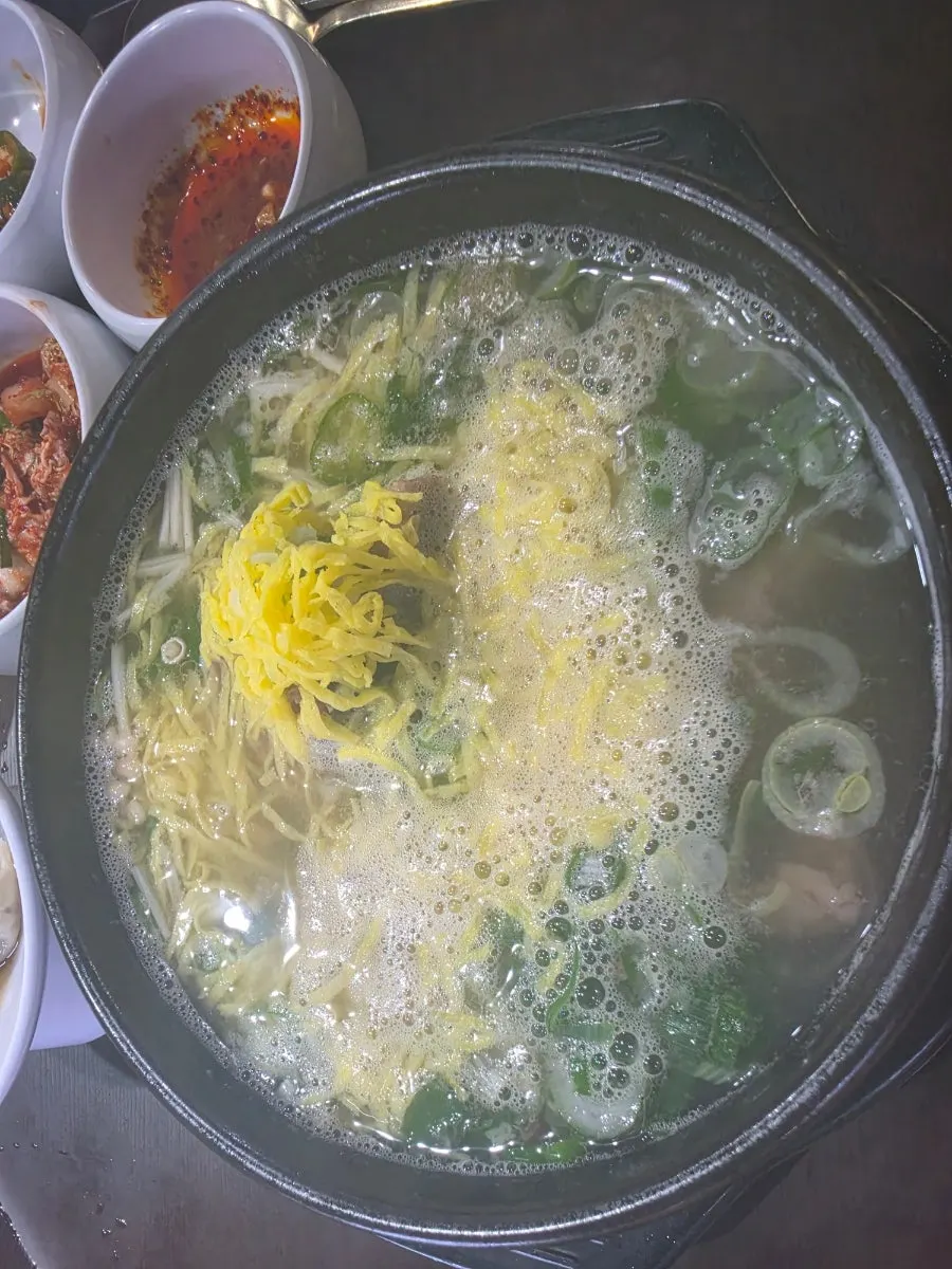 Caldo de bone kalguksu servido junto con arroz