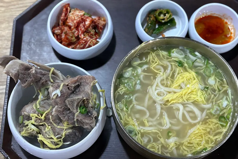Grilled bone meat and kalguksu transferred onto a bone-shaped plate