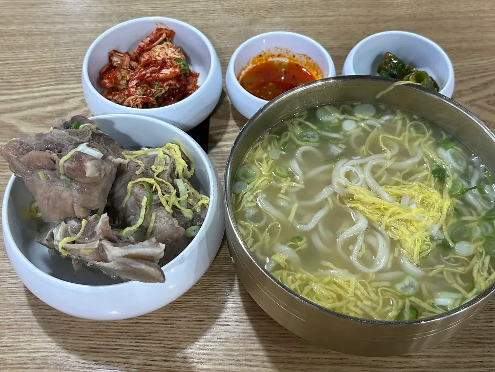 Bone kalguksu meal set up at an outdoor Taste Village table