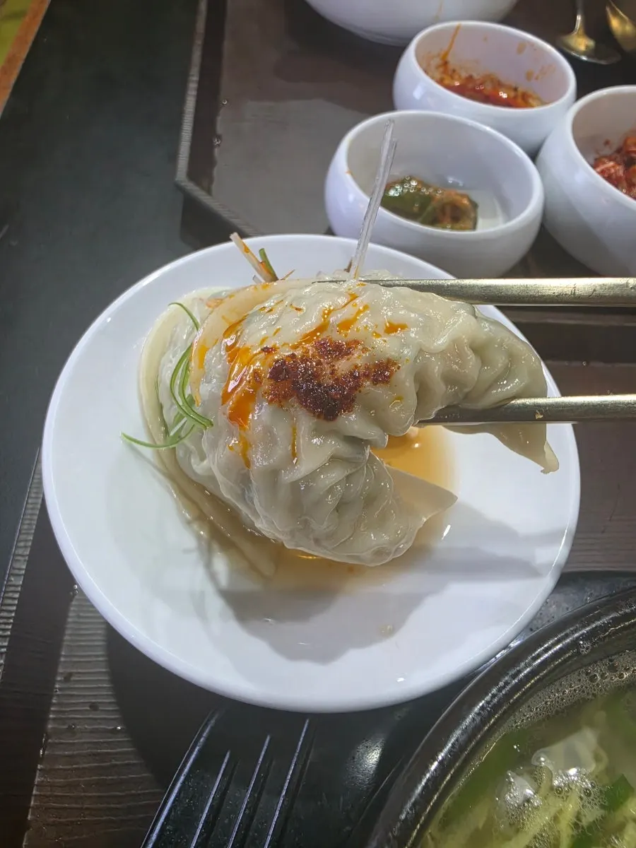 Mandu de carne cortado por la mitad, mostrando el jugo interior