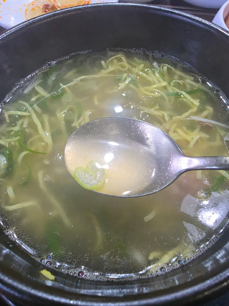 Plato de bone kalguksu con caldo claro y concentrado