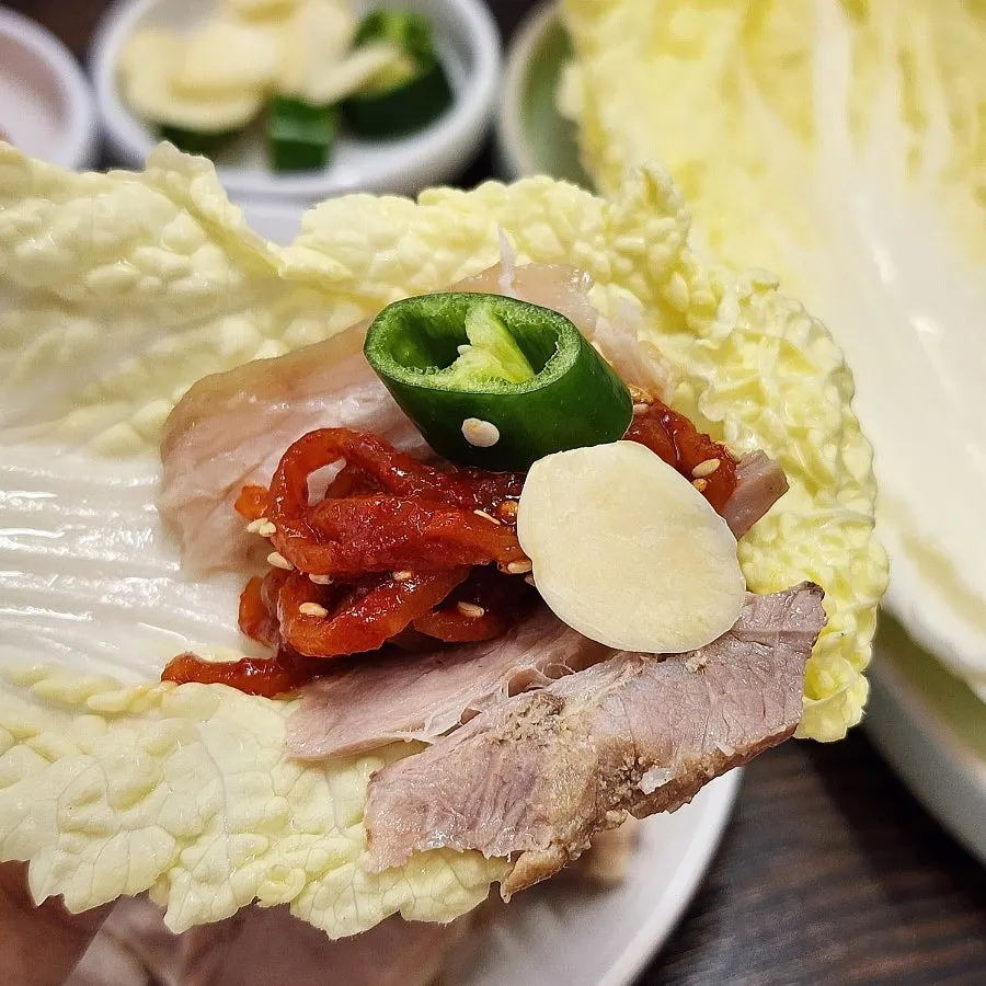 보쌈 수육과 무생채를 곁들인 한 입