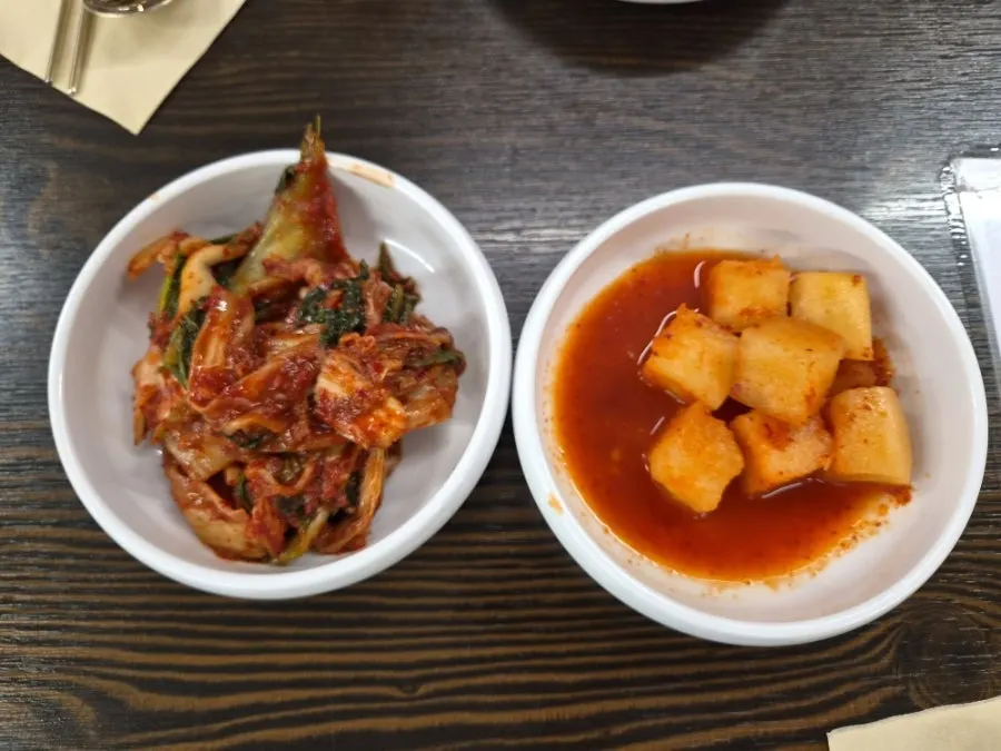 Fresh kimchi and diced radish kimchi served as sides