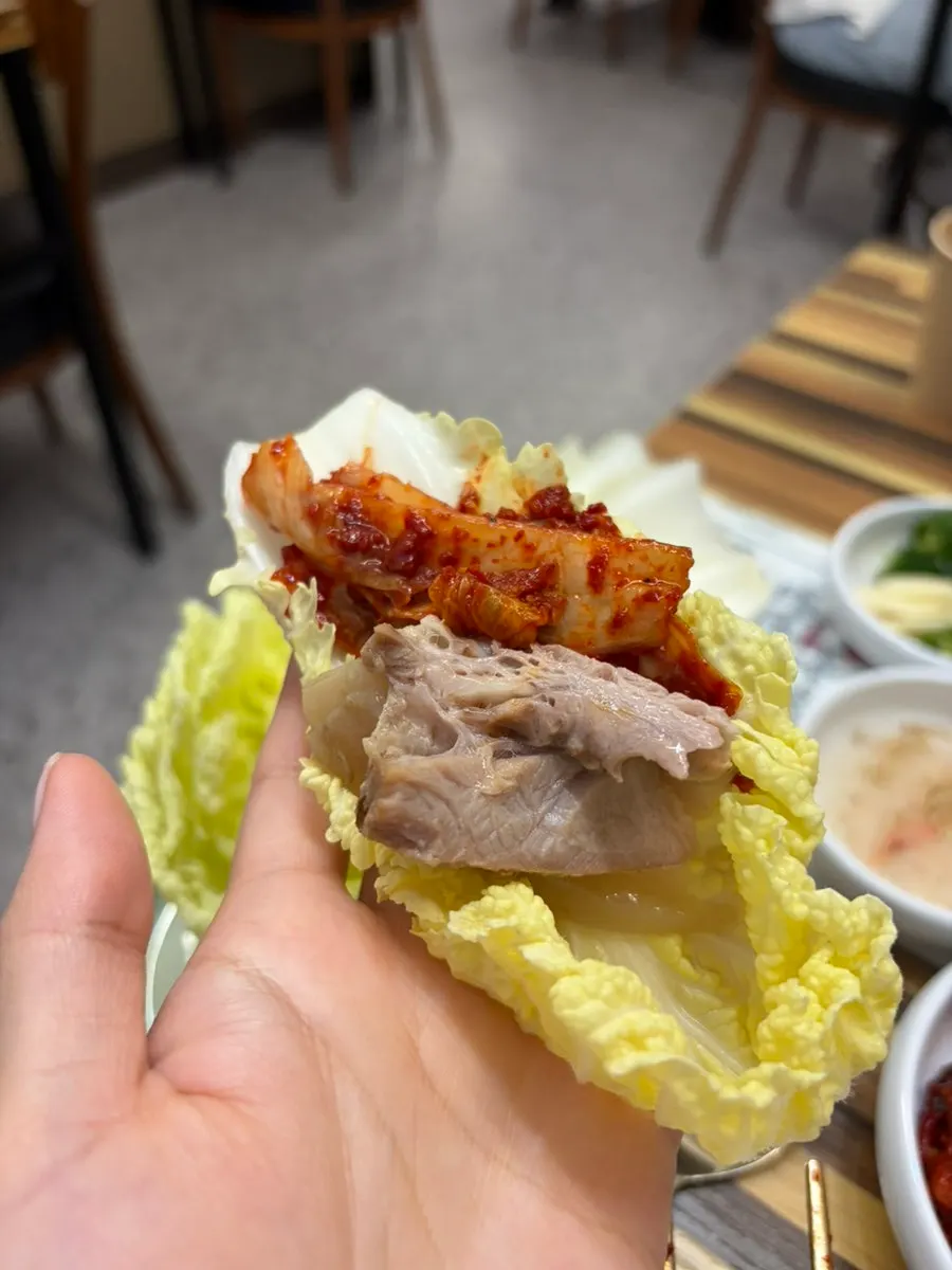 김치 올린 두툼한 수육 한 점