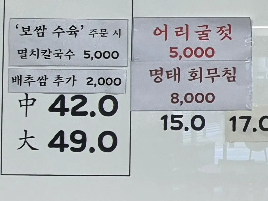 Menu board listing bossam and kalguksu dishes