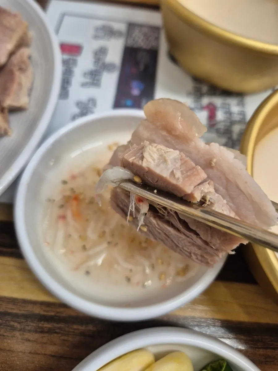 Table with buckwheat raw makgeolli alongside bossam