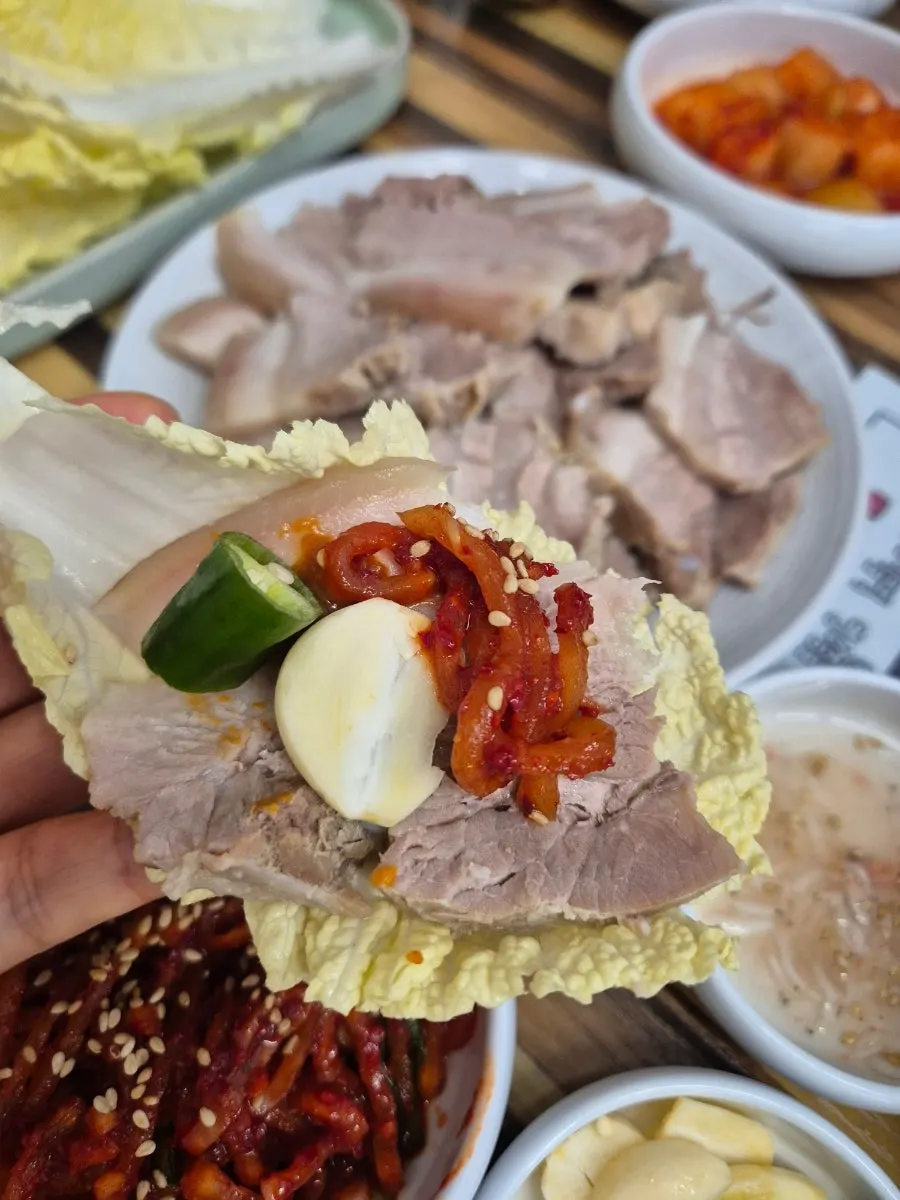 A big bite of cabbage-wrapped bossam