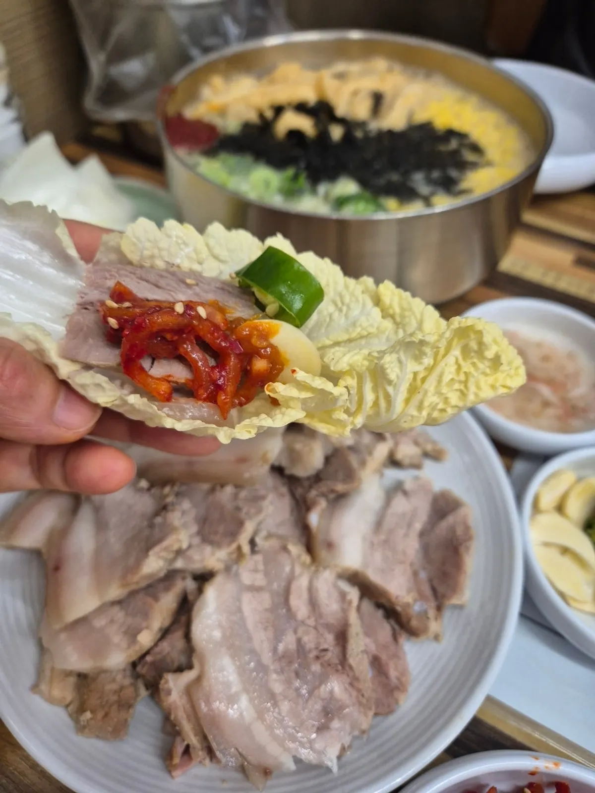 Full table with bossam, anchovy kalguksu, and makgeolli