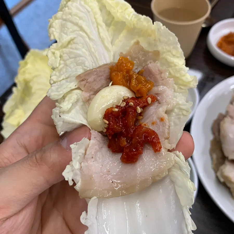 젓가락으로 집어 올린 보쌈 수육