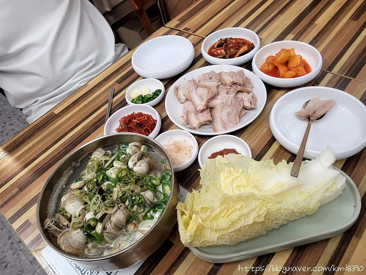 Clam kalguksu and bossam table setting at Pyeongidambaek Ppyeo Kalguksu Main Branch