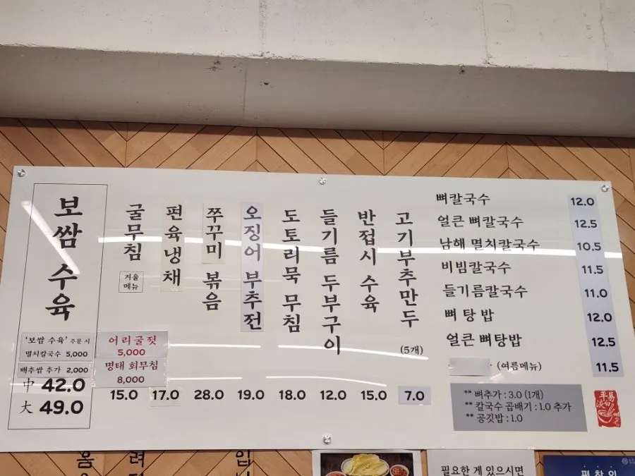 Menu board listing bossam and bone kalguksu