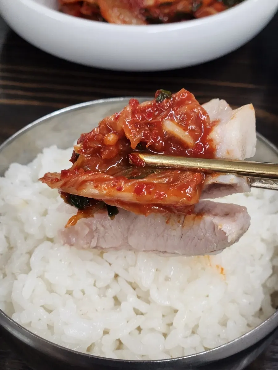 Kimchi placed on top of a piece of bossam
