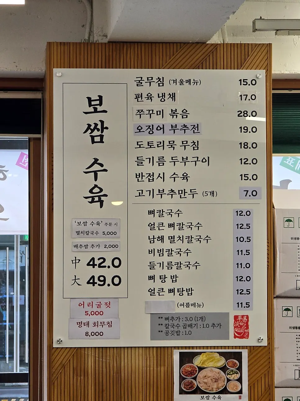 Menu board listing bossam and kalguksu prices