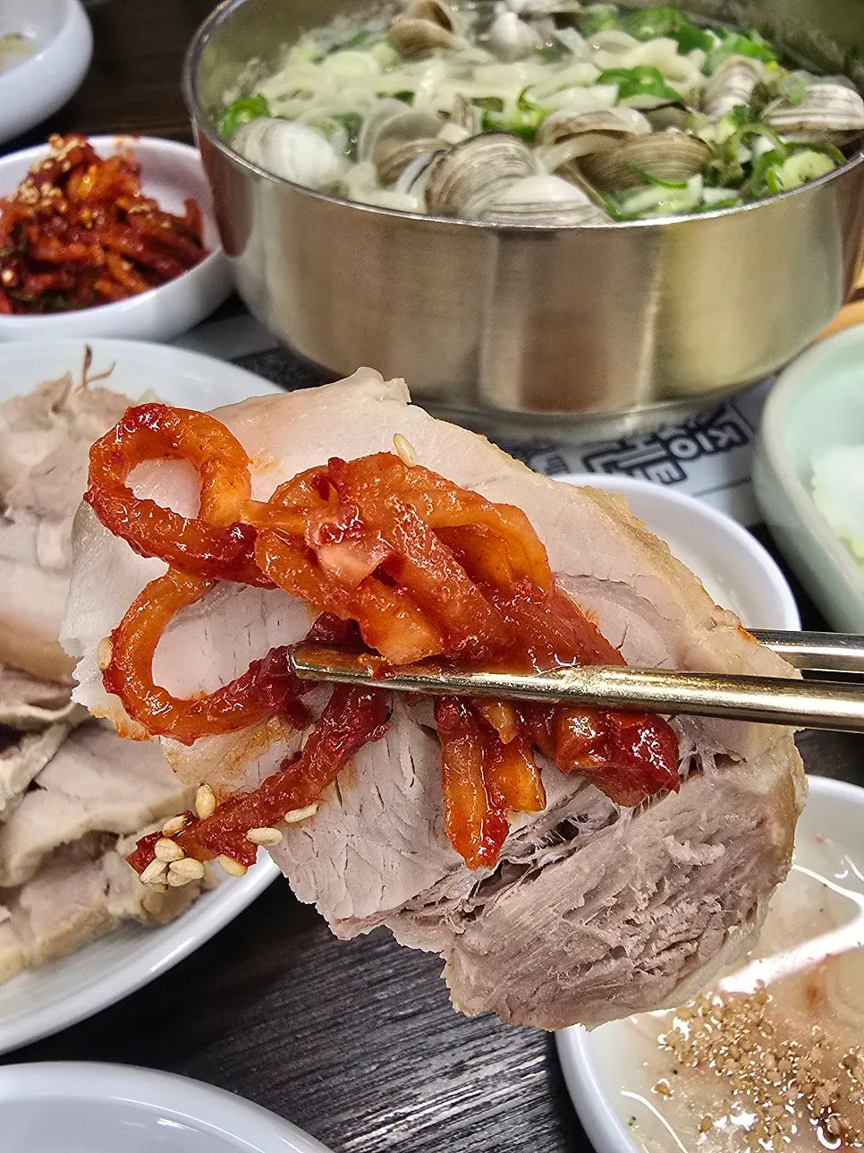 Kimchi, radish salad, and salted shrimp served alongside the bossam