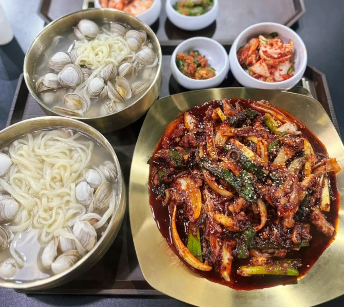 A bowl of clam kalguksu with cheongyang chili and green onion left out