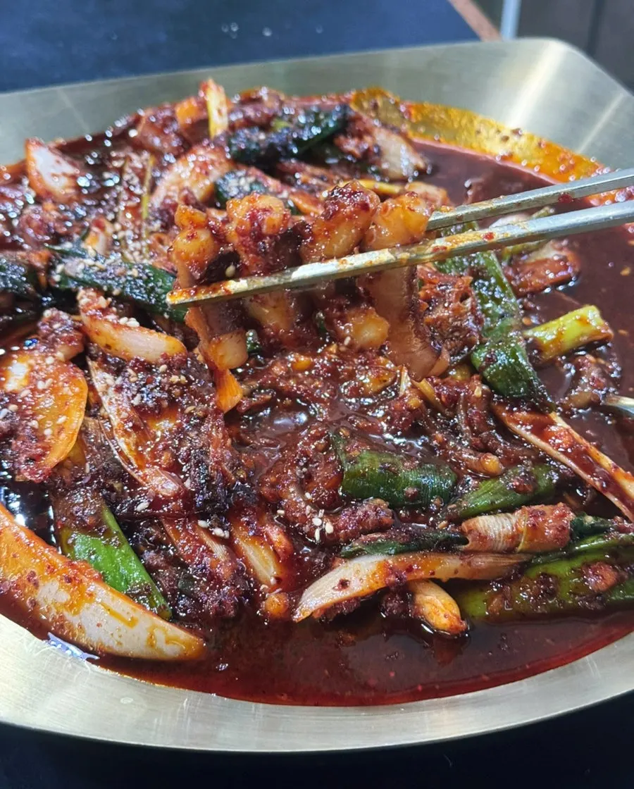 A chopstick-full of kalguksu noodles mixed with octopus stir-fry sauce