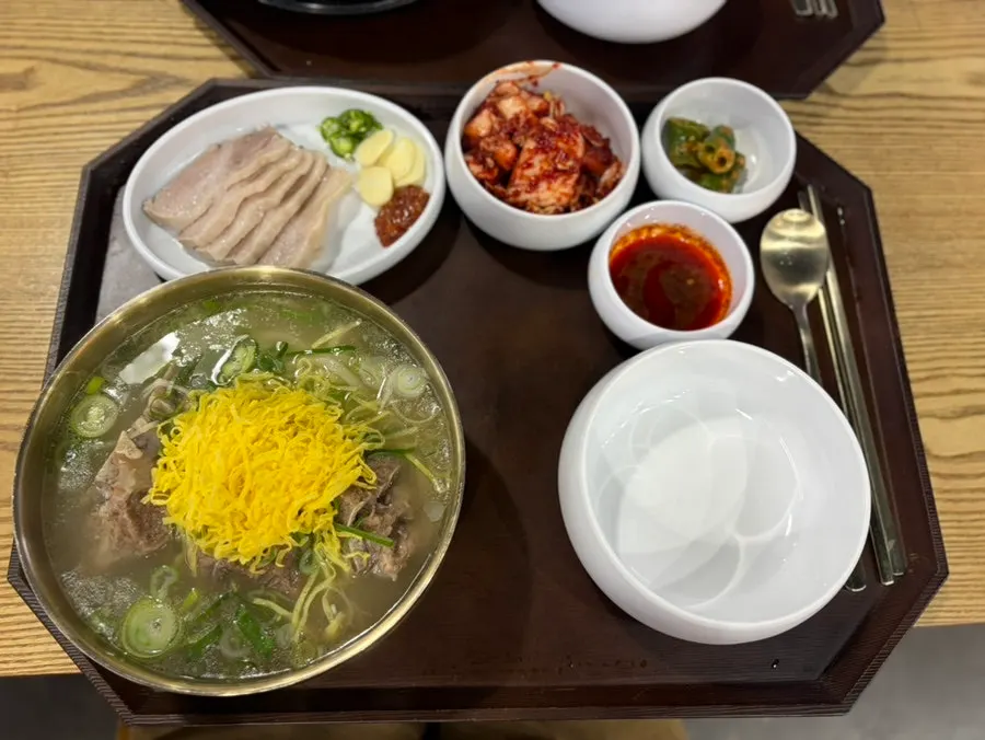 A bowl of bone kalguksu topped with big chunks of bone meat
