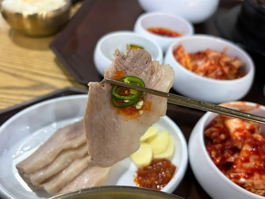 Pork jowl suyuk topped with sauce and chili