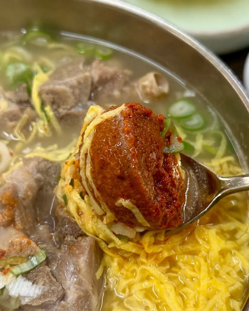 A thick scoop of seasoning paste on top of the soup