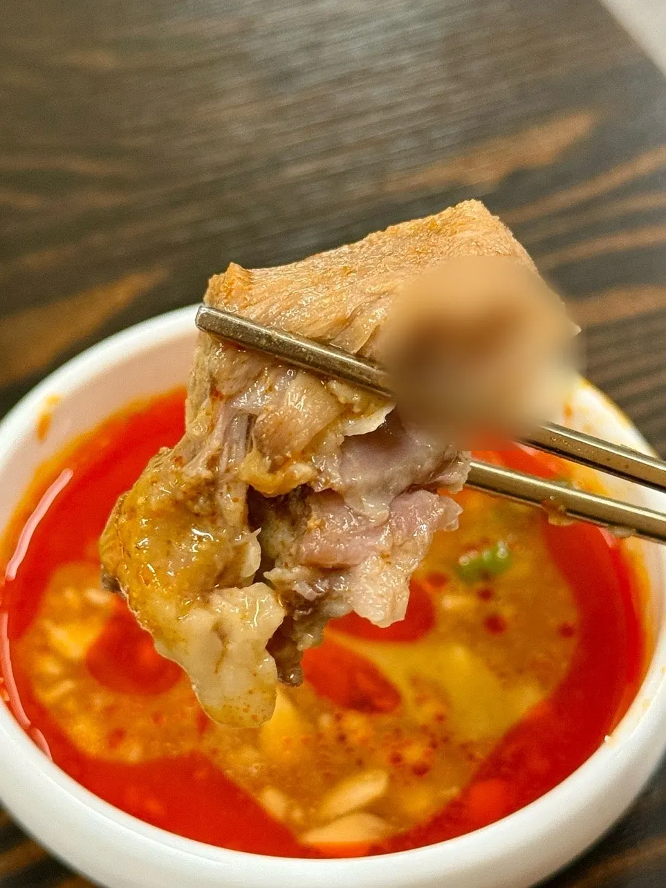 The bone kalguksu broth turned red after stirring in the paste